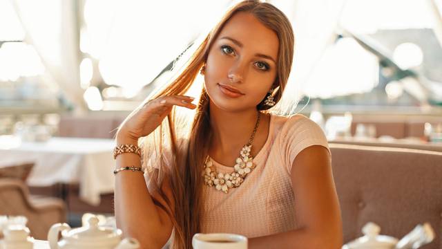 Beautiful young woman in a cafe drinking tea