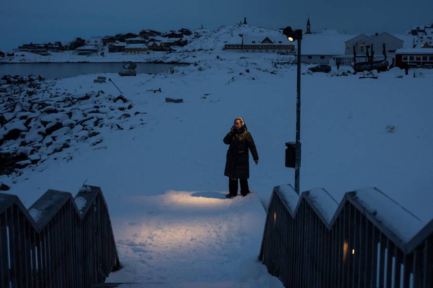 People walk by the sea at Nuuk's old harbour