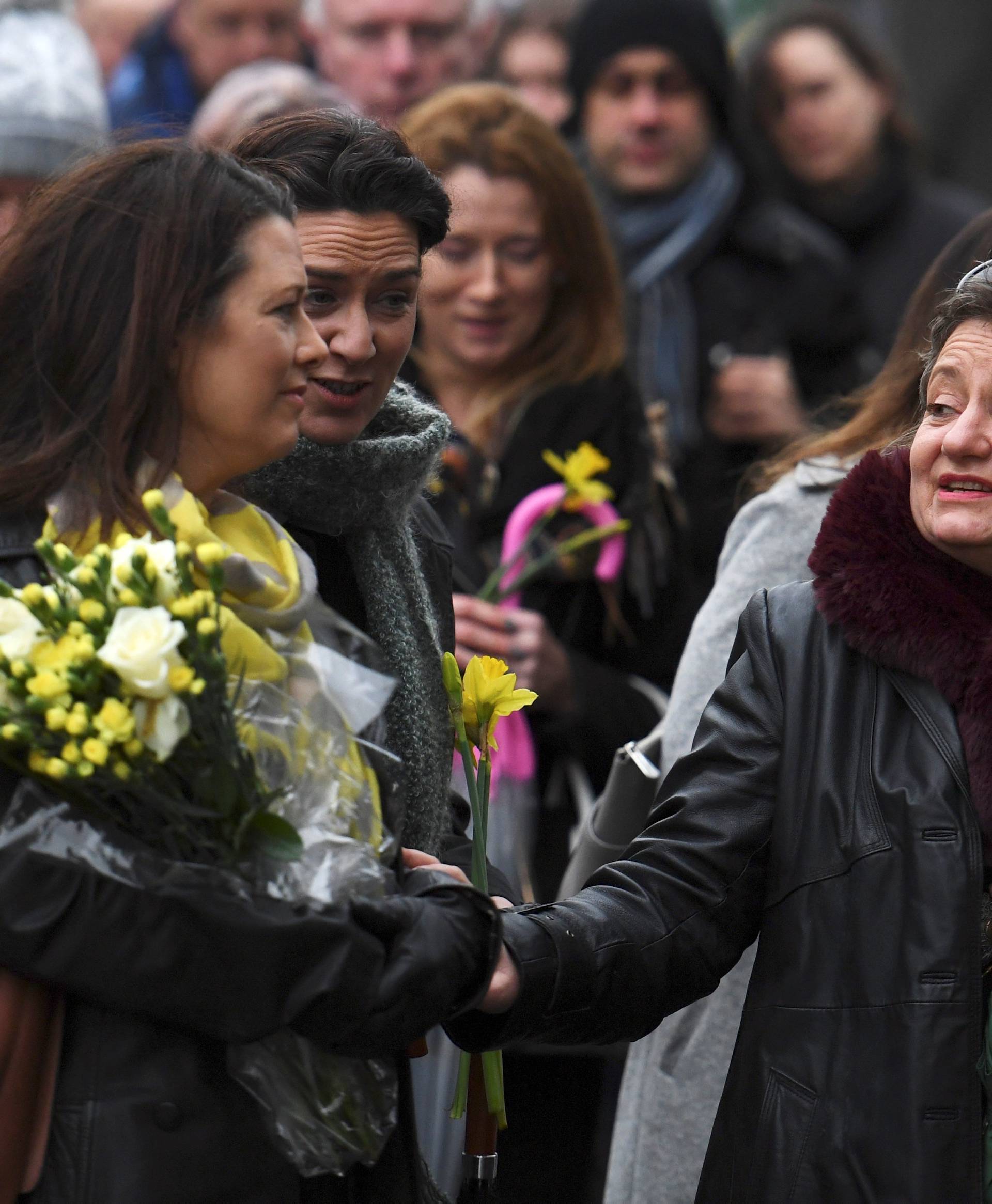 Schoolfriends bring yellow flowers to represent sunshine as they queue up to view Cranberries singer Dolores O'Riordan's coffin during her public reposal at St. Joseph's Church in Limerick