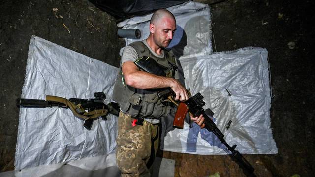 FILE PHOTO: Ukrainian service member checks his weapon at a position near a frontline in Zaporizhzhia region