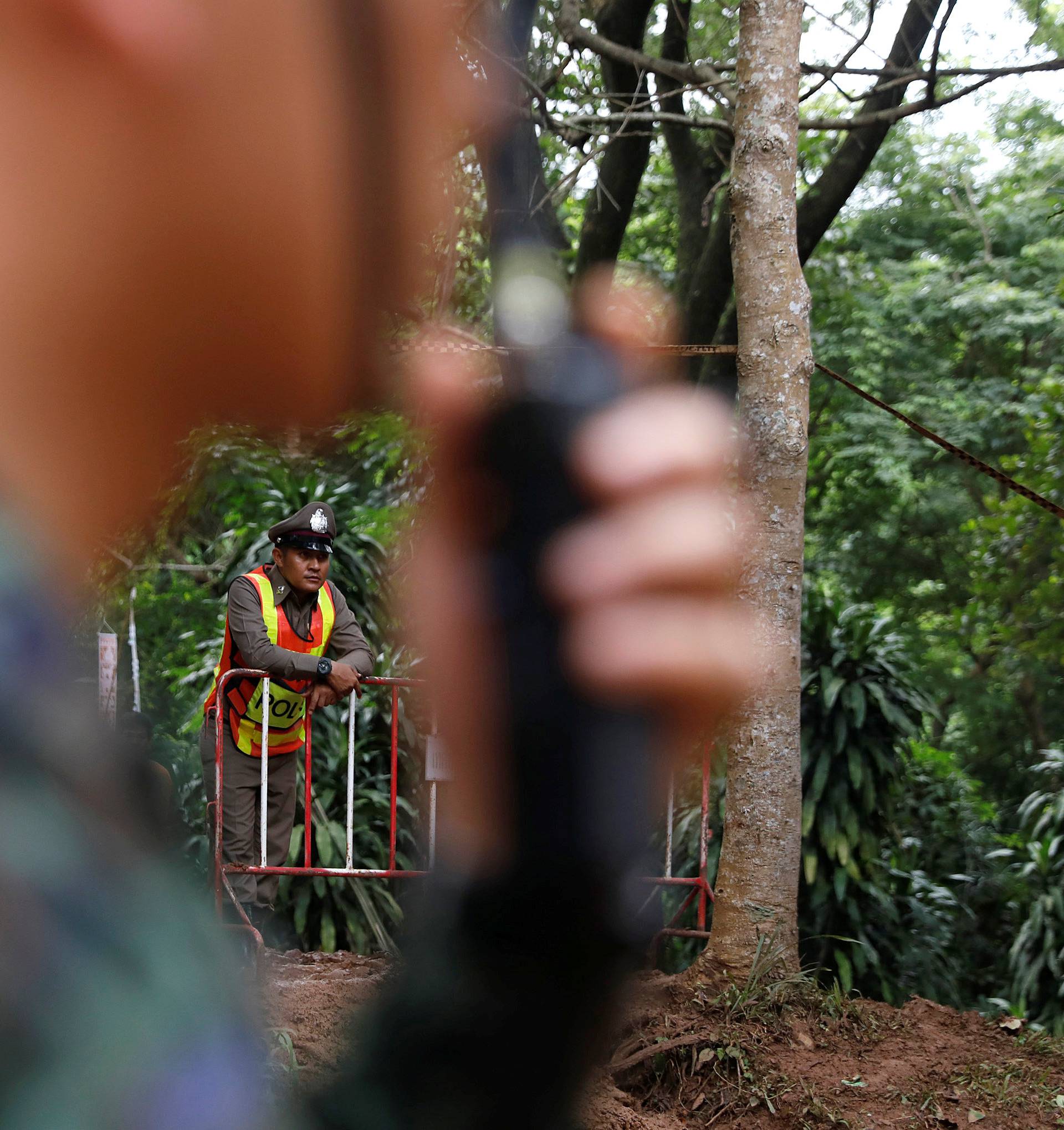 A solider and a police officer take a guard near the Tham Luang cave complex, as a search for members of an under-16 soccer team and their coach continues, in the northern province of Chiang Rai