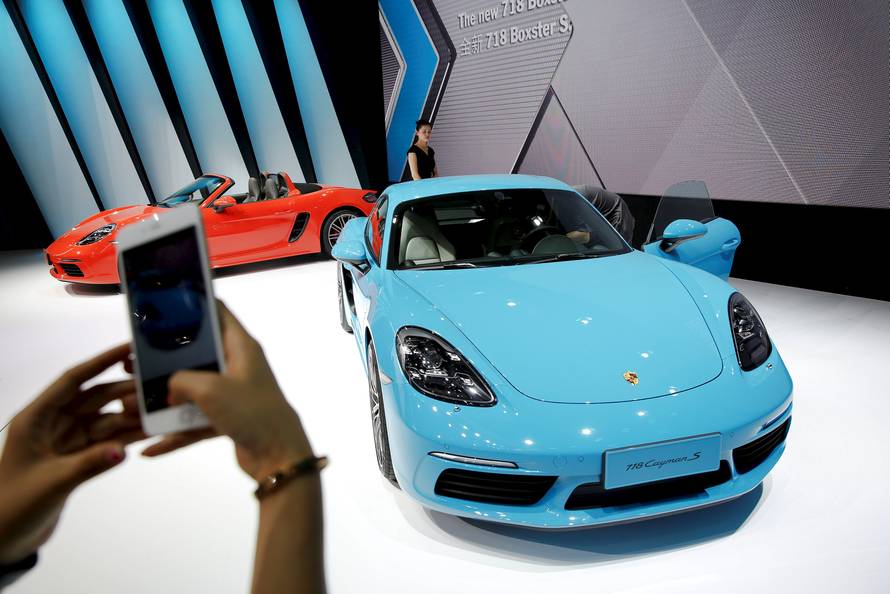 A visitor takes pictures of a new Porsche 718 Cayman S presented during Auto China 2016 auto show in Beijing