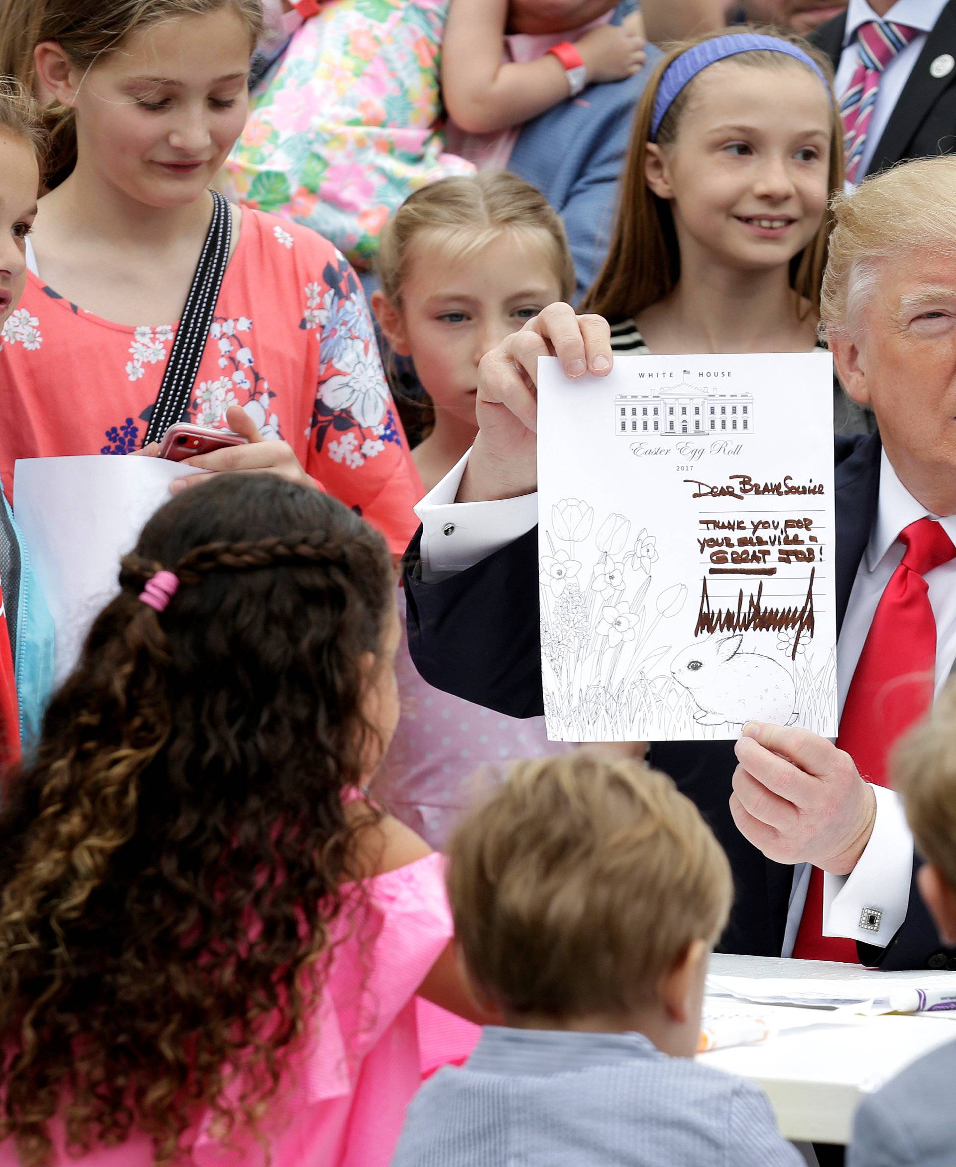 U.S. President Donald Trump holds an Easter greeting card he made that will be sent to a member of the military at the 139th annual White House Easter Egg Roll on the South Lawn of the White House in Washington