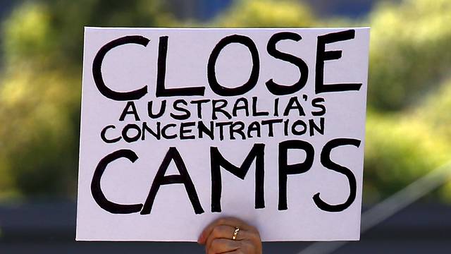 A protester holds a placard during a rally in support of refugees in central Sydney, Australia