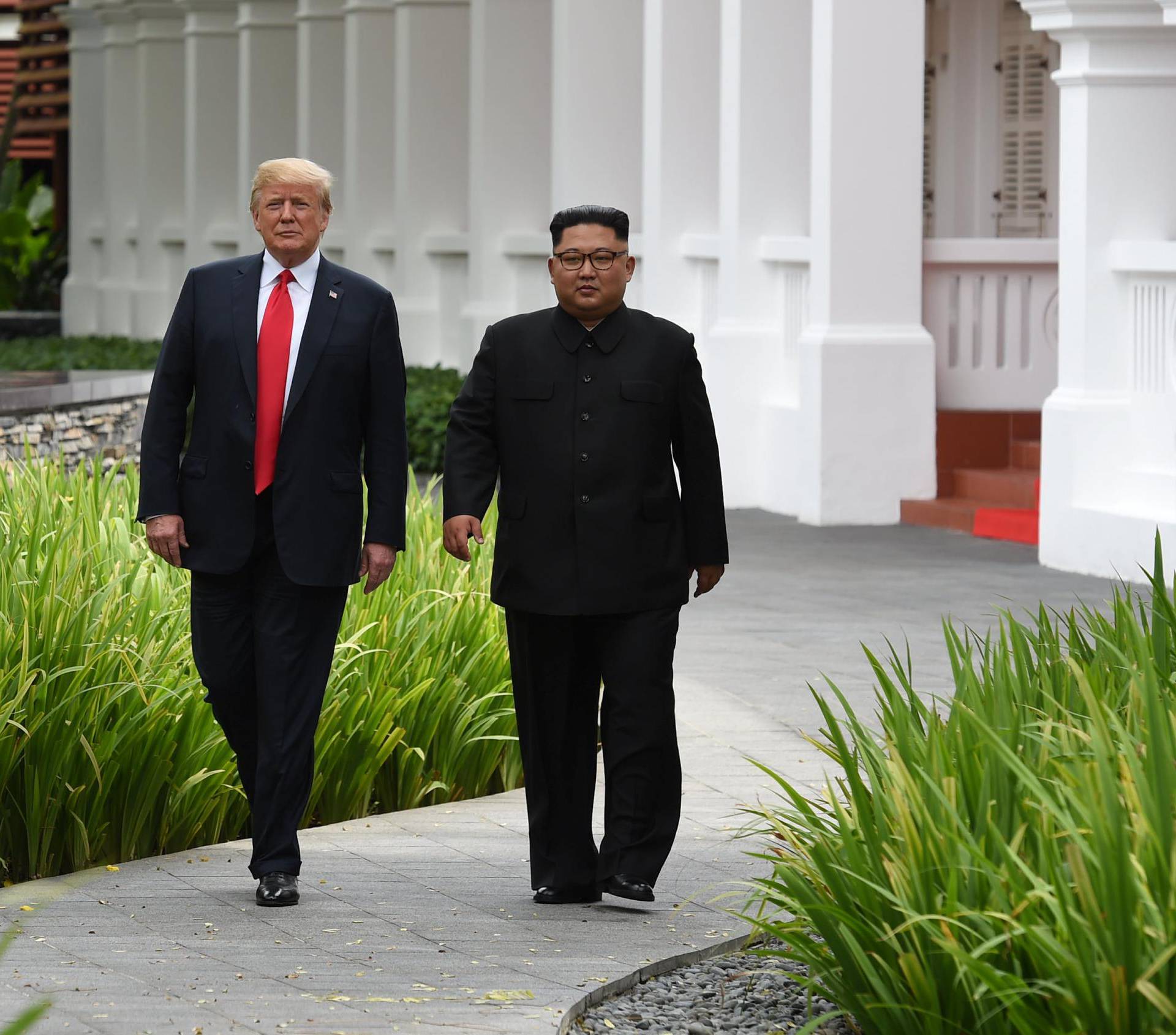 U.S. President Donald Trump and North Korean leader Kim Jong Un walk in the Capella Hotel after their working lunch, on Sentosa island in Singapore