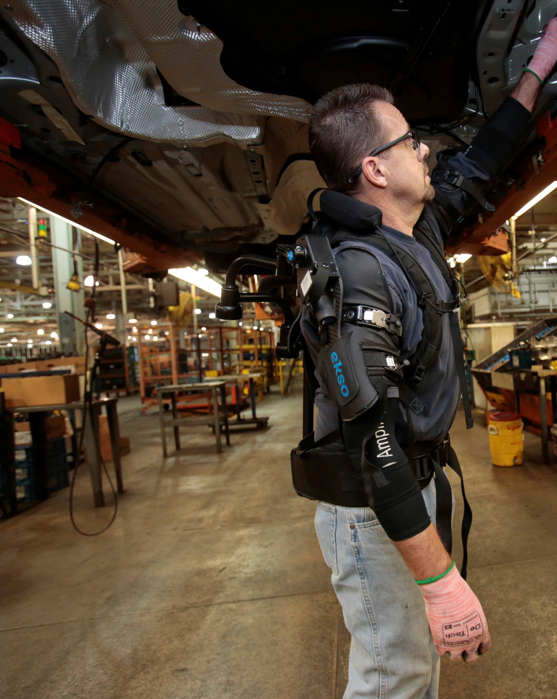 Ford Motor Co assembly worker Paul Collins wears an EksoVest as he works on the assembly line producing the Ford Focus and C-max at Wayne Assembly plant in Wayne