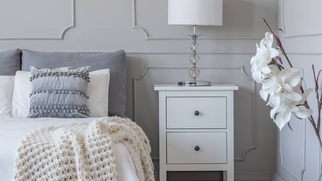 Simple white lamp on wooden night stand table with two drawers n