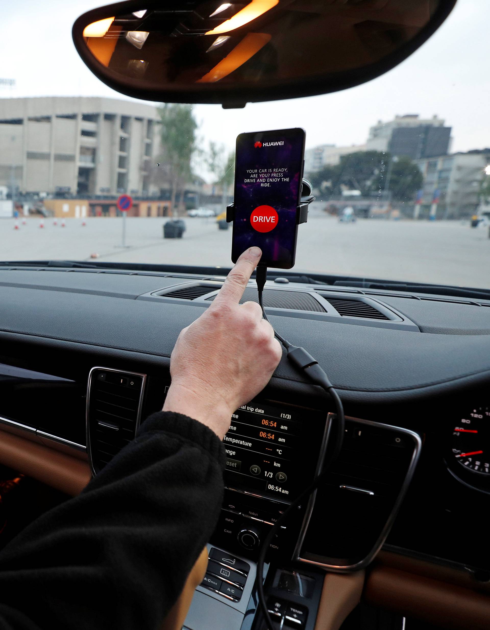 An engineer points to a Huawei Mate 10 Pro mobile used to control a driverless car during the Mobile World Congress in Barcelona
