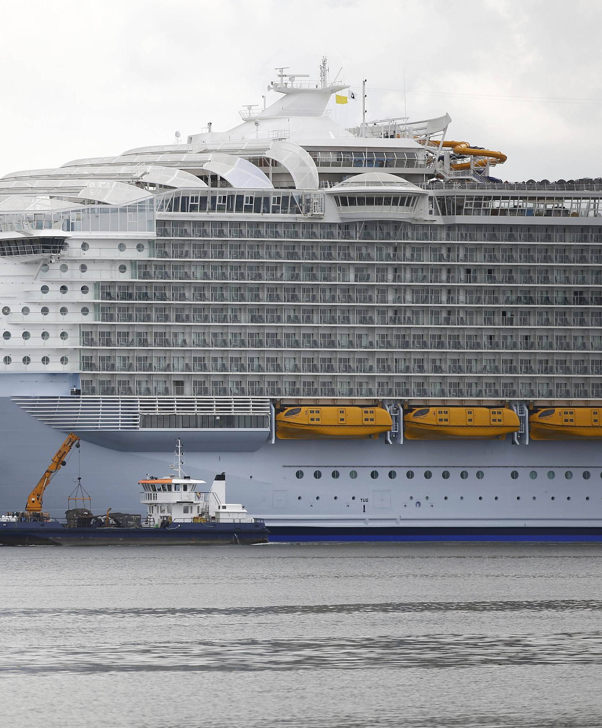 A small boats cruises past the worlds largest cruise ship, the 361 metres long, Harmony of the Seas, berthed in port ahead of its maiden voyage, in Southampton