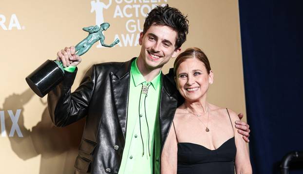 LOS ANGELES, CALIFORNIA, USA - FEBRUARY 23: Timothee Chalamet, winner of the Outstanding Performance by a Male Actor in a Leading Role award for 'A Complete Unknown,' and mother Nicole Flender pose in the press room at the 31st Annual Screen Actors Guild