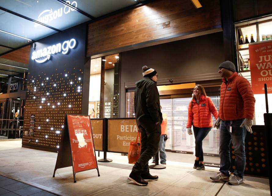 Amazon employees are pictured outside the Amazon Go brick-and-mortar grocery store without lines or checkout counters, in Seattle Washington