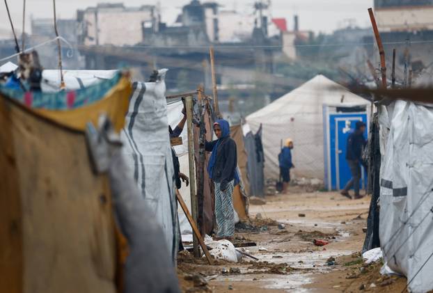 Displaced Palestinians shelter in a tent camp, on a rainy day in Nuseirat