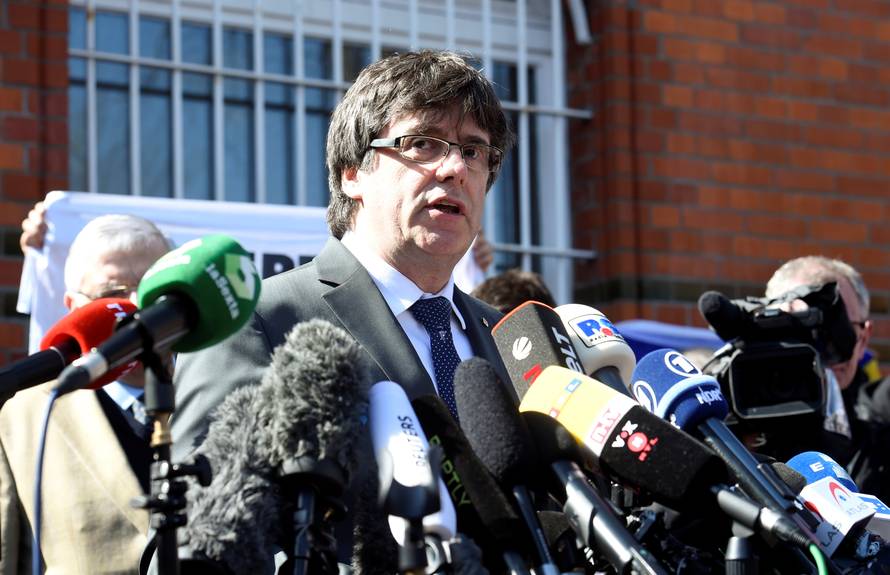Catalonia's former leader Carles Puigdemont talks to the media as he leaves the prison in Neumuenster