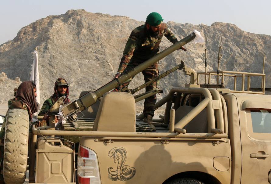 Taliban soldiers load a rocket launcher in a vehicle near Torkham border