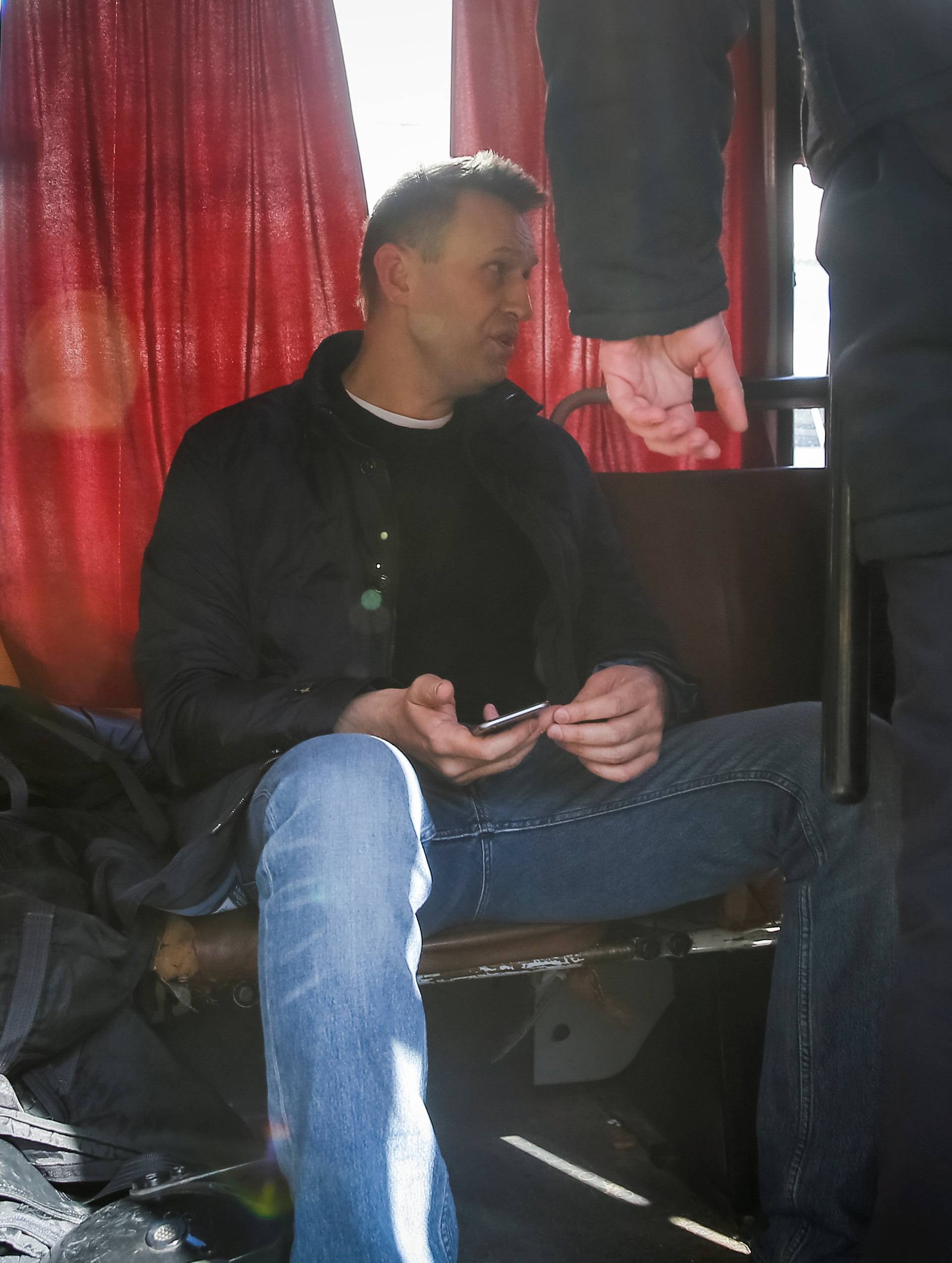 Anti-corruption campaigner and opposition figure Alexei Navalny sits inside a police van after being detained during a rally in Moscow, Russia