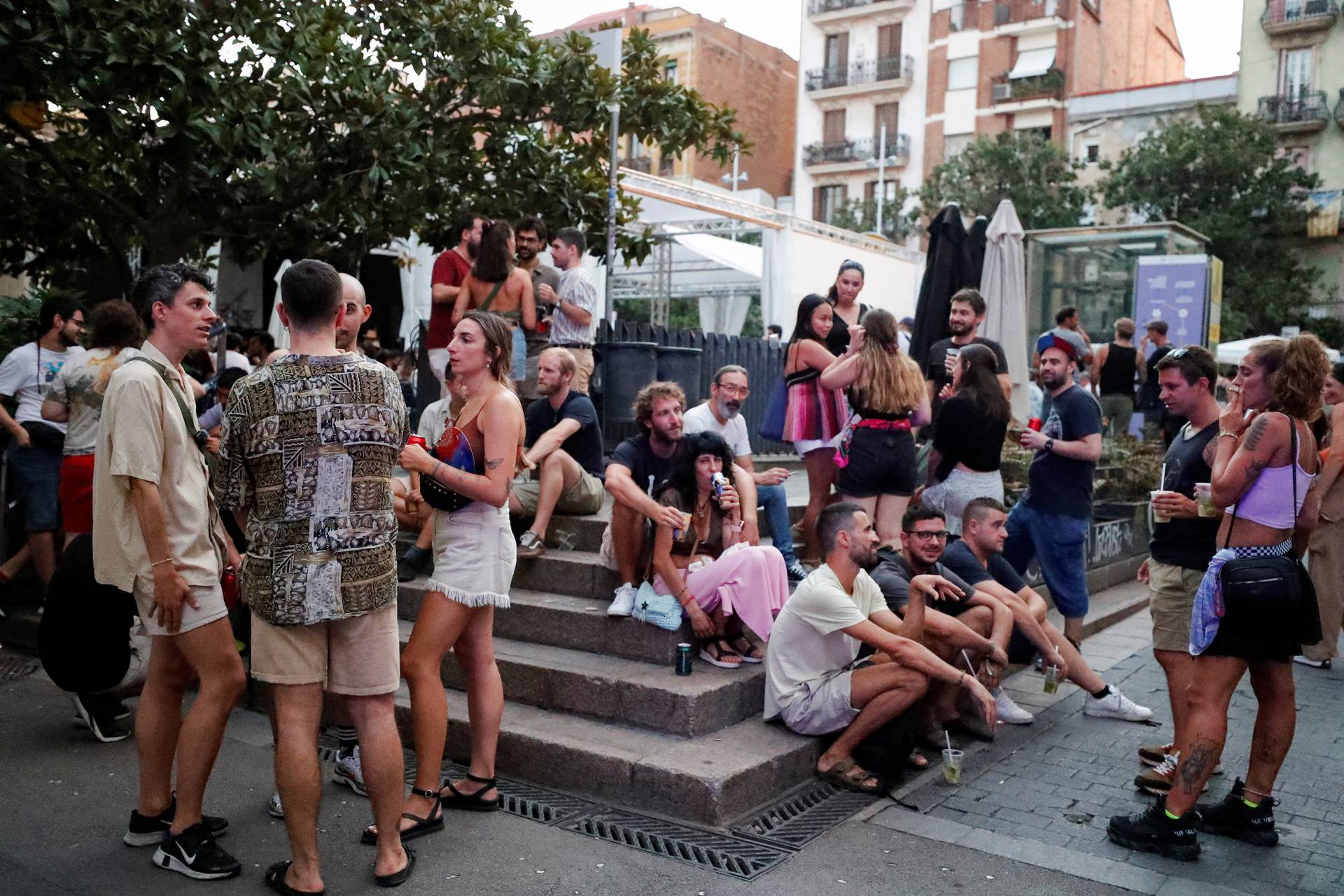 Tourists and residents drink on a street in Gracia neighbourhood during a heatwave of the summer, in Barcelona
