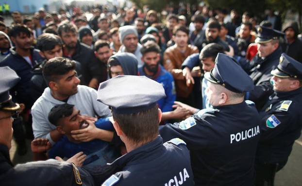 Migrants scuffle with police as they try to block a road in front of the refugee camp Miral in Velika Kladusa