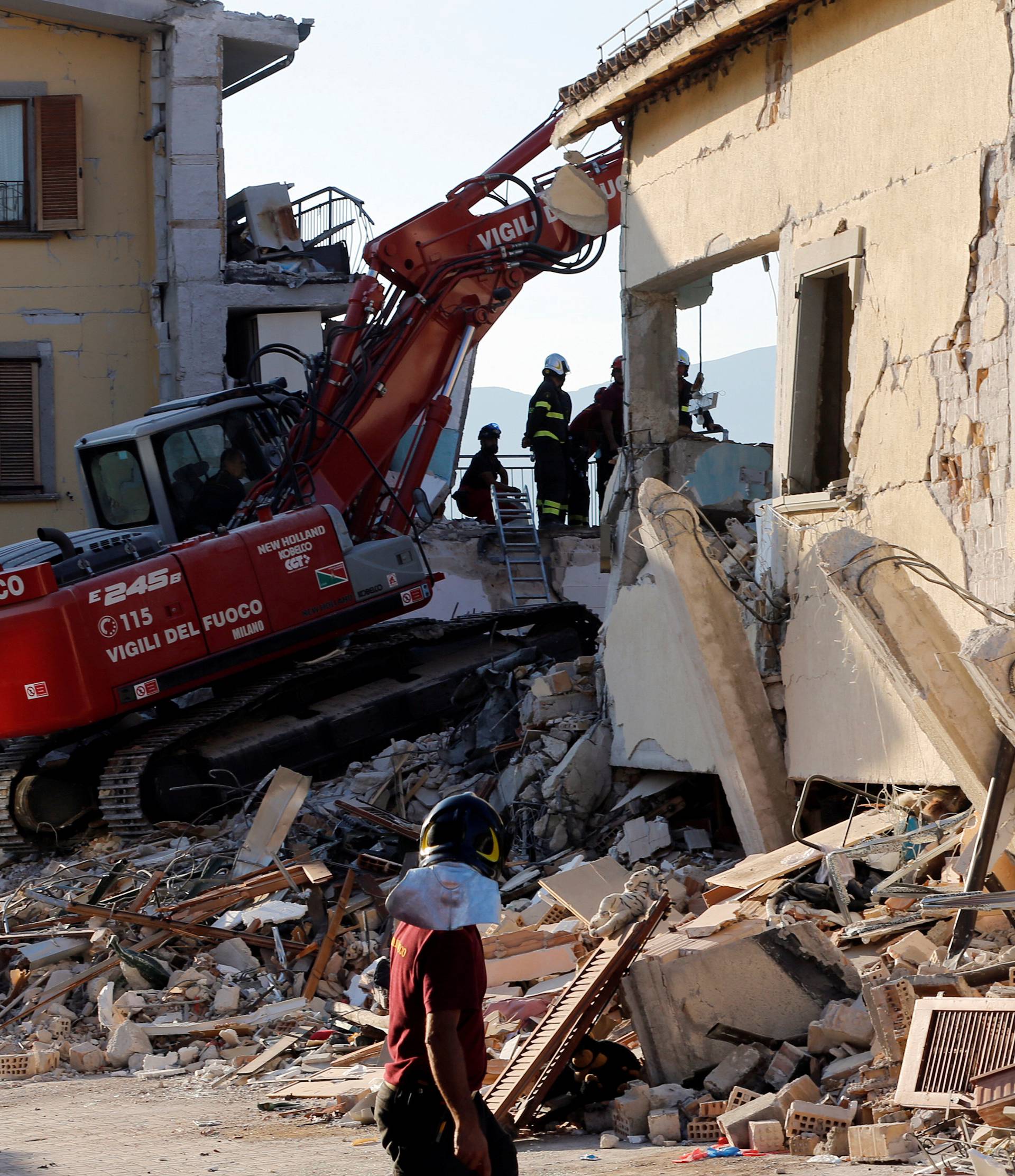 Firefighters work next to collapsed Hotel Roma following an earthquake in Amatrice