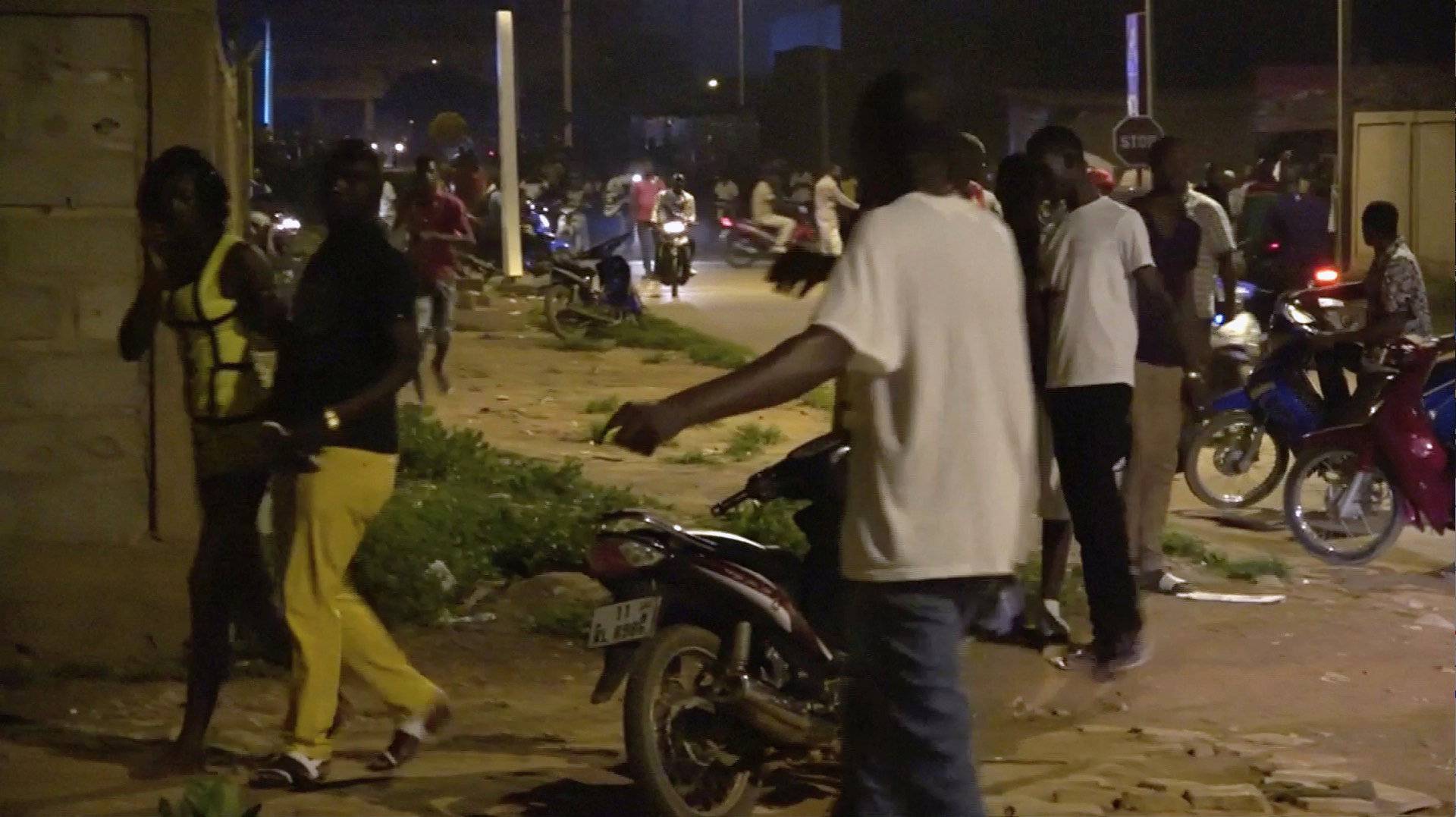 Restaurant customers run in the street following an attack by gunmen on a restaurant in Ouagadougou, Burkina Faso