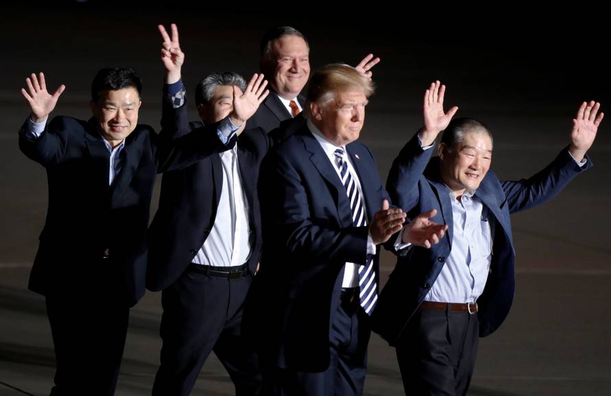 The three Americans formerly held hostage in North Korea gesture next to U.S.President Donald Trump and Secretary of State Mike Pompeo, upon their arrival at Joint Base Andrews