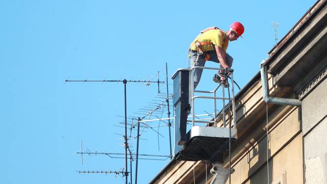 Zagreb: Radnik u košari dizalice sanira krov zgrade