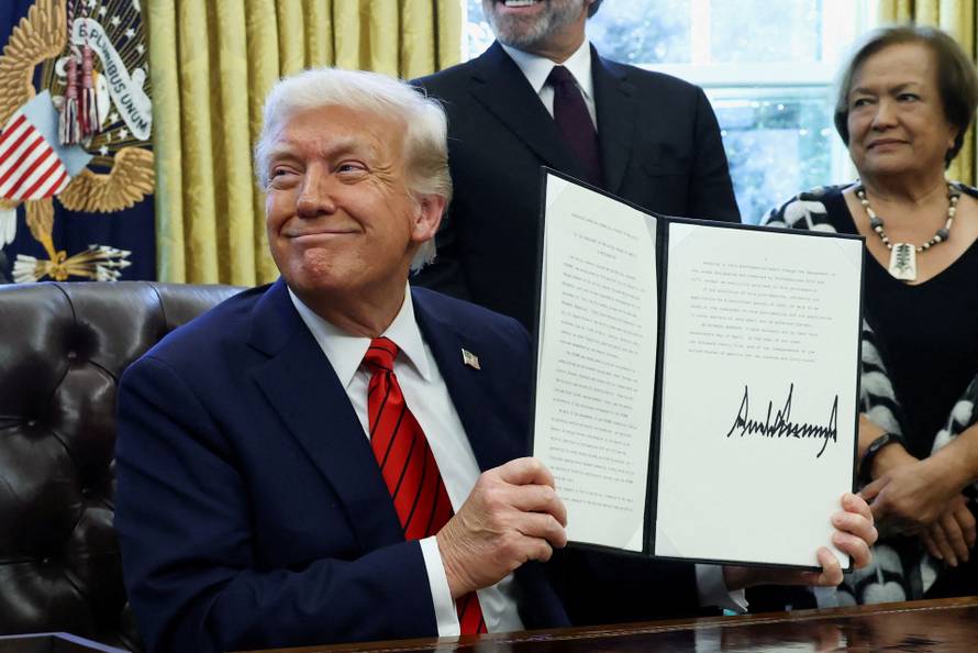 FILE PHOTO: U.S. President Donald Trump signs executive orders in the Oval Office at the White House