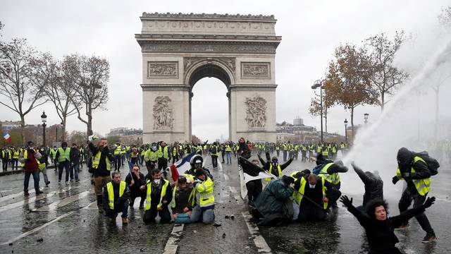 Protesters wearing yellow vests, a symbol of a French drivers' protest against higher diesel taxes, face off with French riot police during clashes at the Place de l'Etoile near the Arc de Triomphe in Paris