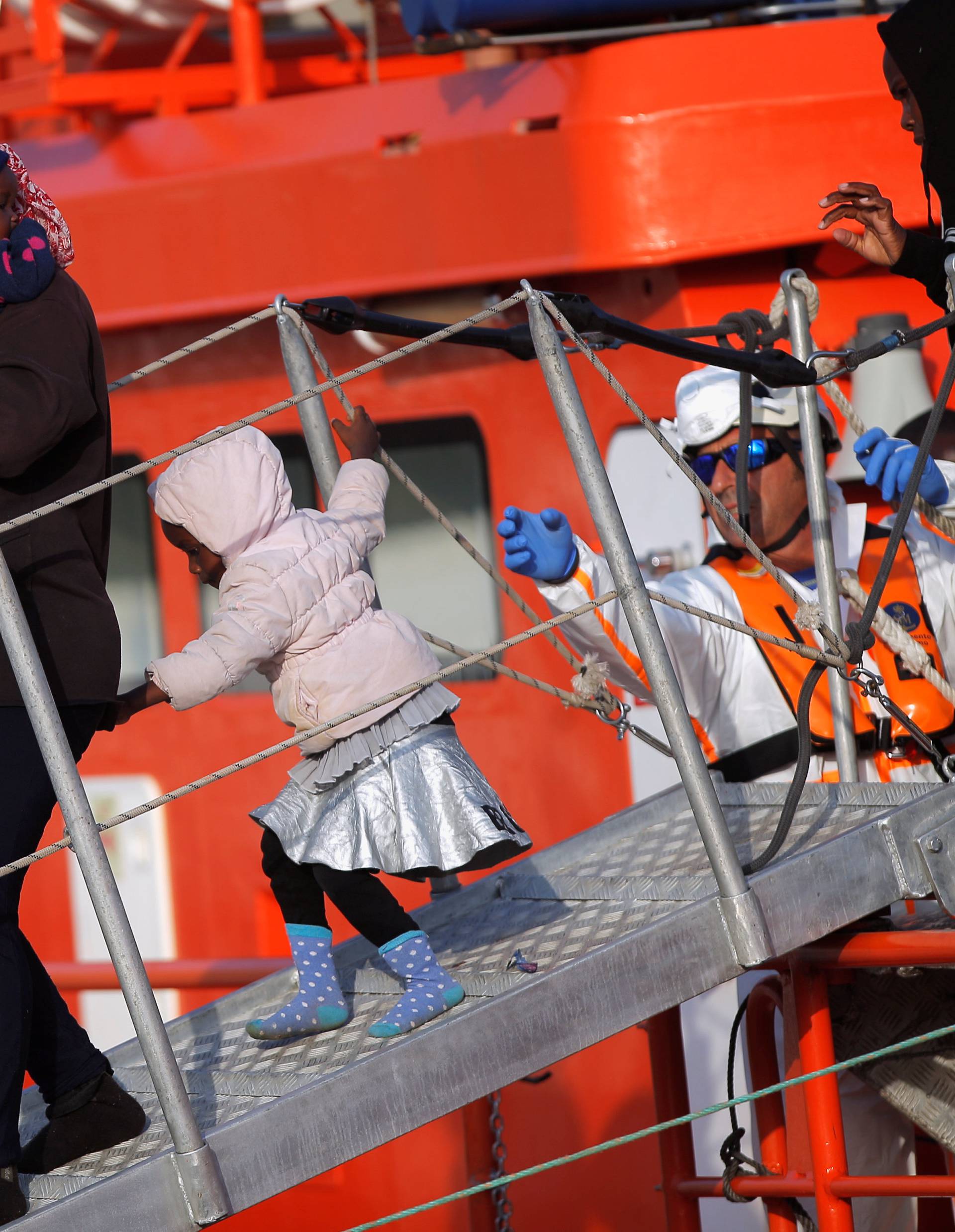 Migrants leave a rescue boat after arriving at the port of Malaga