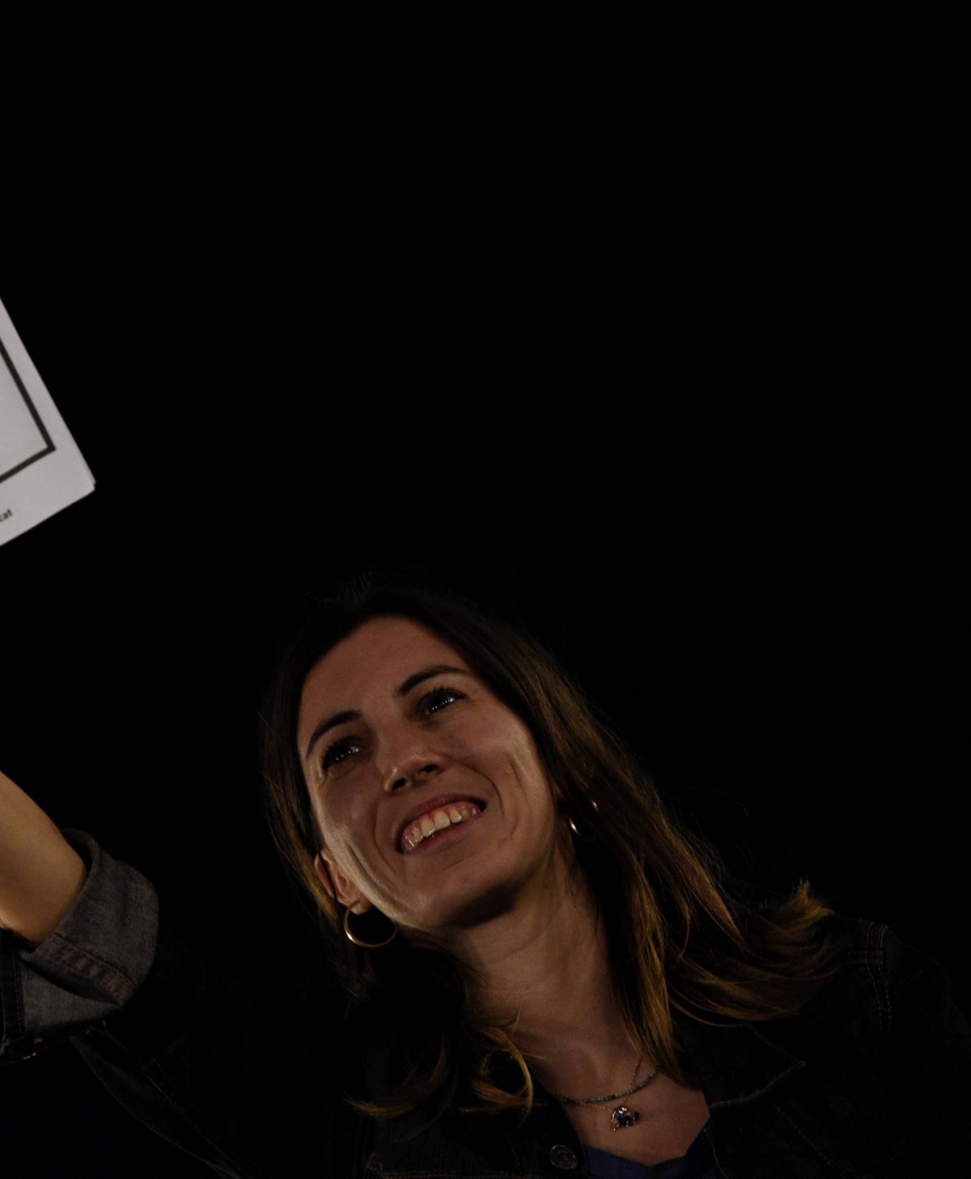 A woman shows up a flyer reading "We vote to be free" as she attends a closing rally in favour of the banned October 1 independence referendum in Barcelona