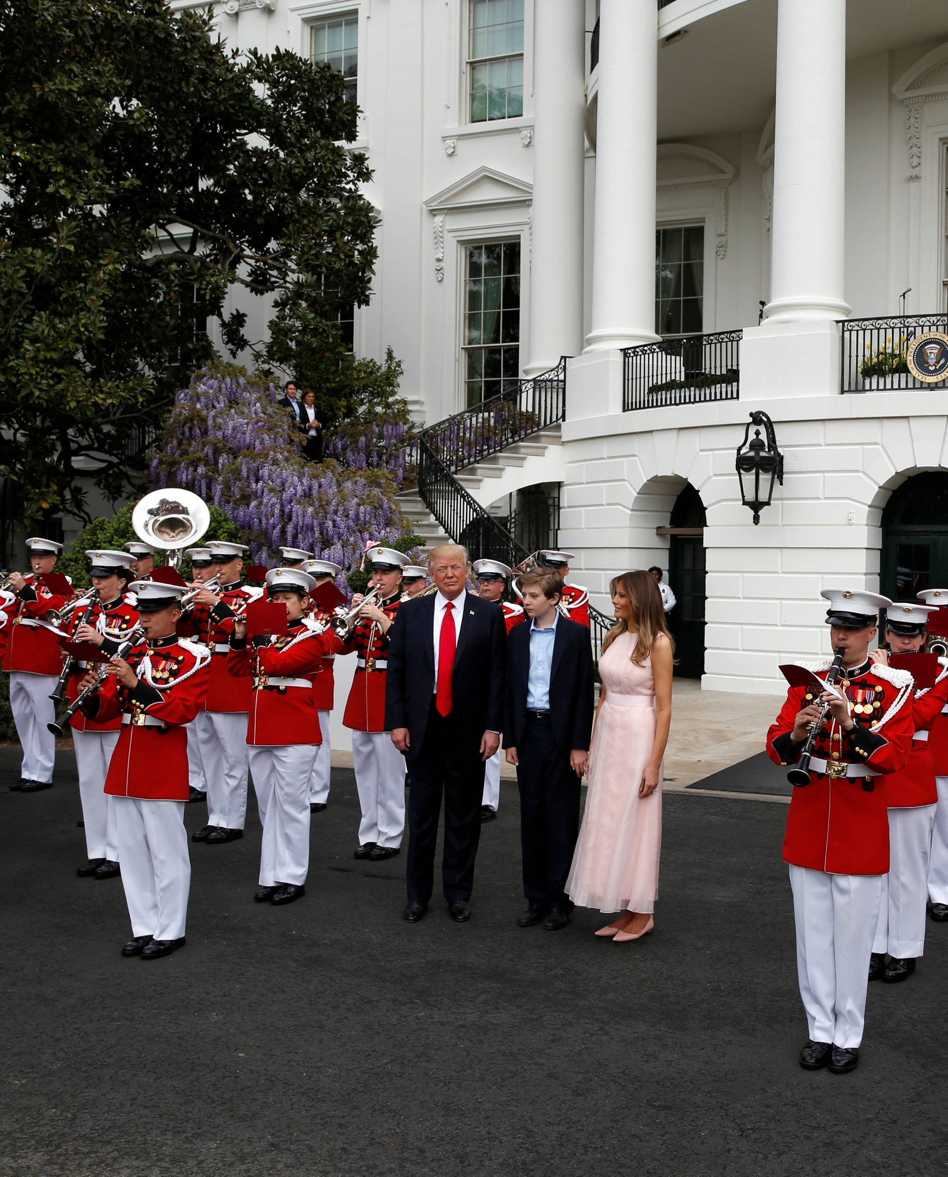 U.S. President Donald Trump, U.S. first lady Melania Trump and their son Barron listen as a military band plays during the 139th annual White House Easter Egg Roll on the South Lawn of the White House in Washington