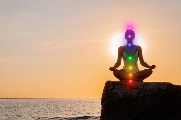 Woman,Is,Meditating,With,Glowing,Seven,Chakras,On,Stone,At