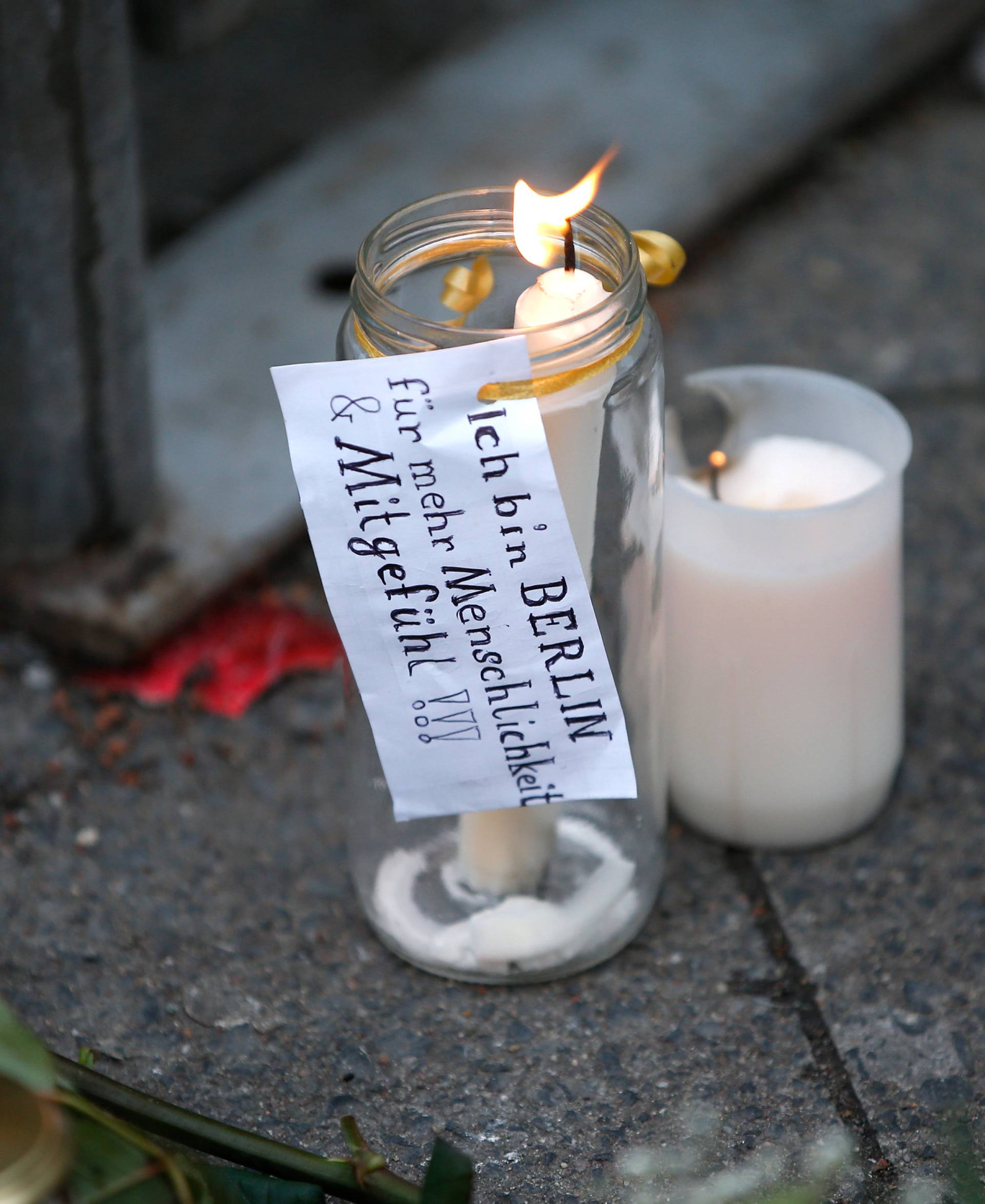 A candle with a sticker reading "I am Berlin - For more humanity and compassion" near the scene where a truck ploughed into a crowded Christmas market in the German capital last night in Berlin