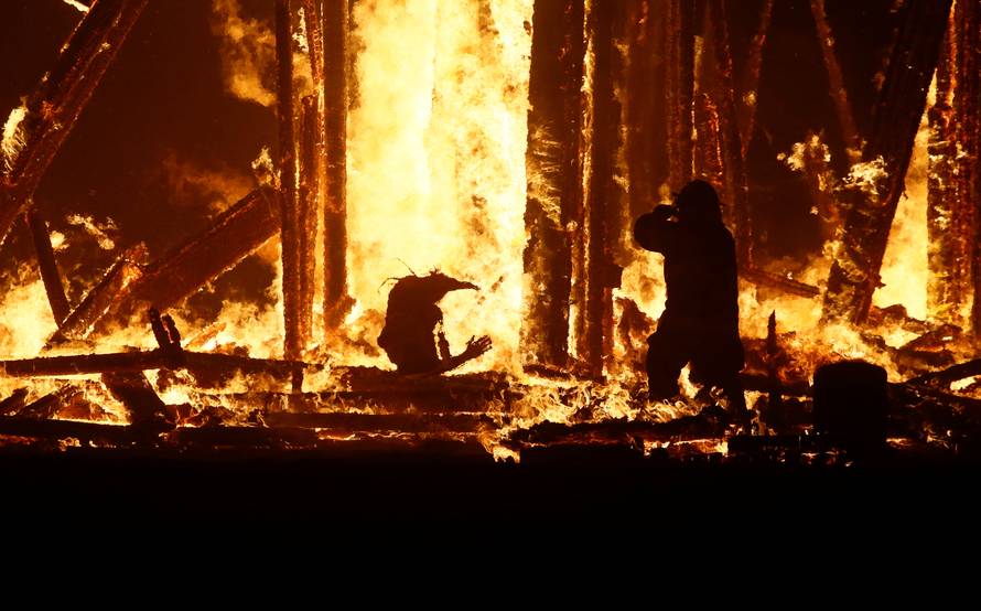 Burning Man participant runs into the flames of the "Man Burn" at the Burning Man arts and music festival in the Black Rock Desert of Nevada