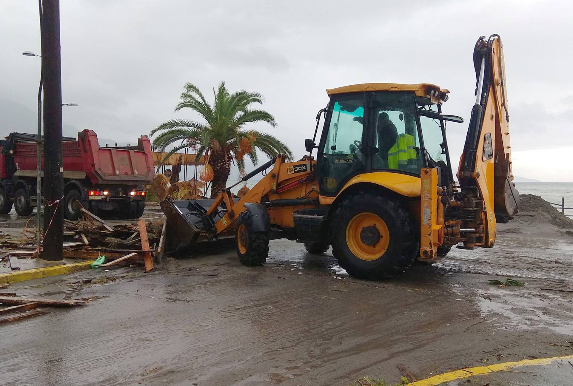 An excavator collects debris from the seaside following a cyclone in Kalamata
