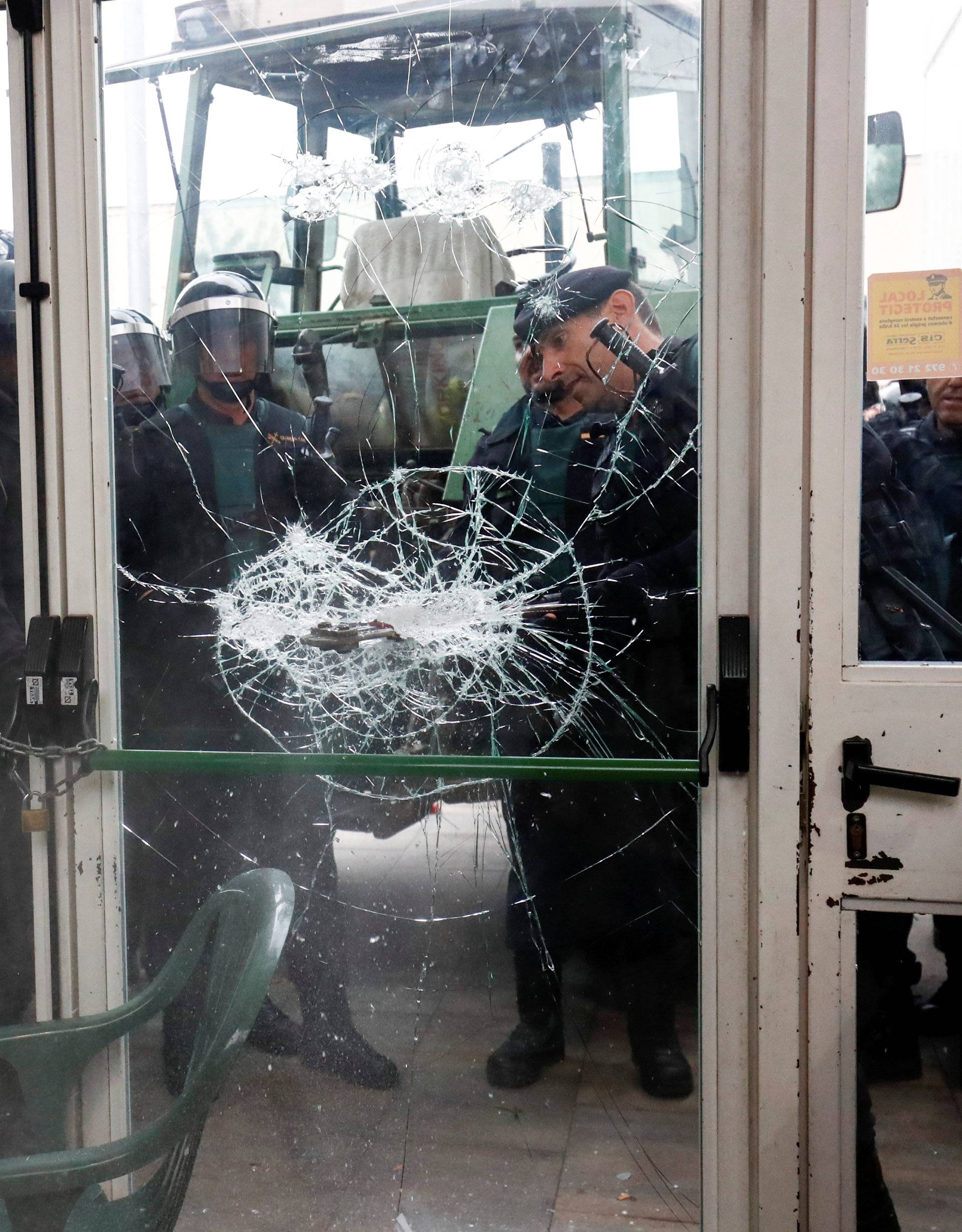 Officers break through door at polling station for banned independence referendum in Sant Julia de Ramis