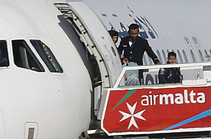 People disembark from a hijacked Libyan Afriqiyah Airways Airbus A320 on the runway at Malta Airport