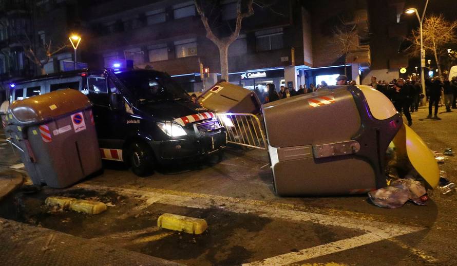 A Catalan police van drives through barricades placed by protestors during skirmishes after former regional president Carles Puigdemont was detained in Germany, in Barcelona