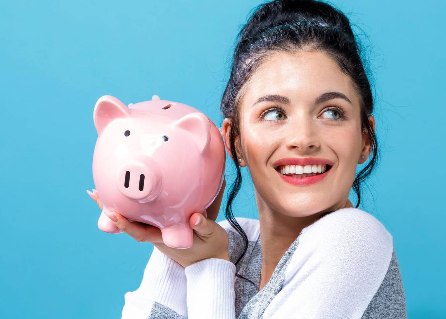 Young woman with a piggy bank