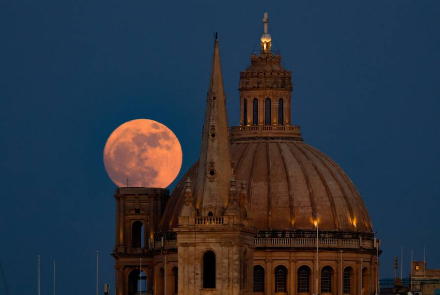 A full moon known as the Strawberry Moon rises behind St Paul's Anglican Cathedral and the Basilica of Our Lady of Mount Carmel in Valletta
