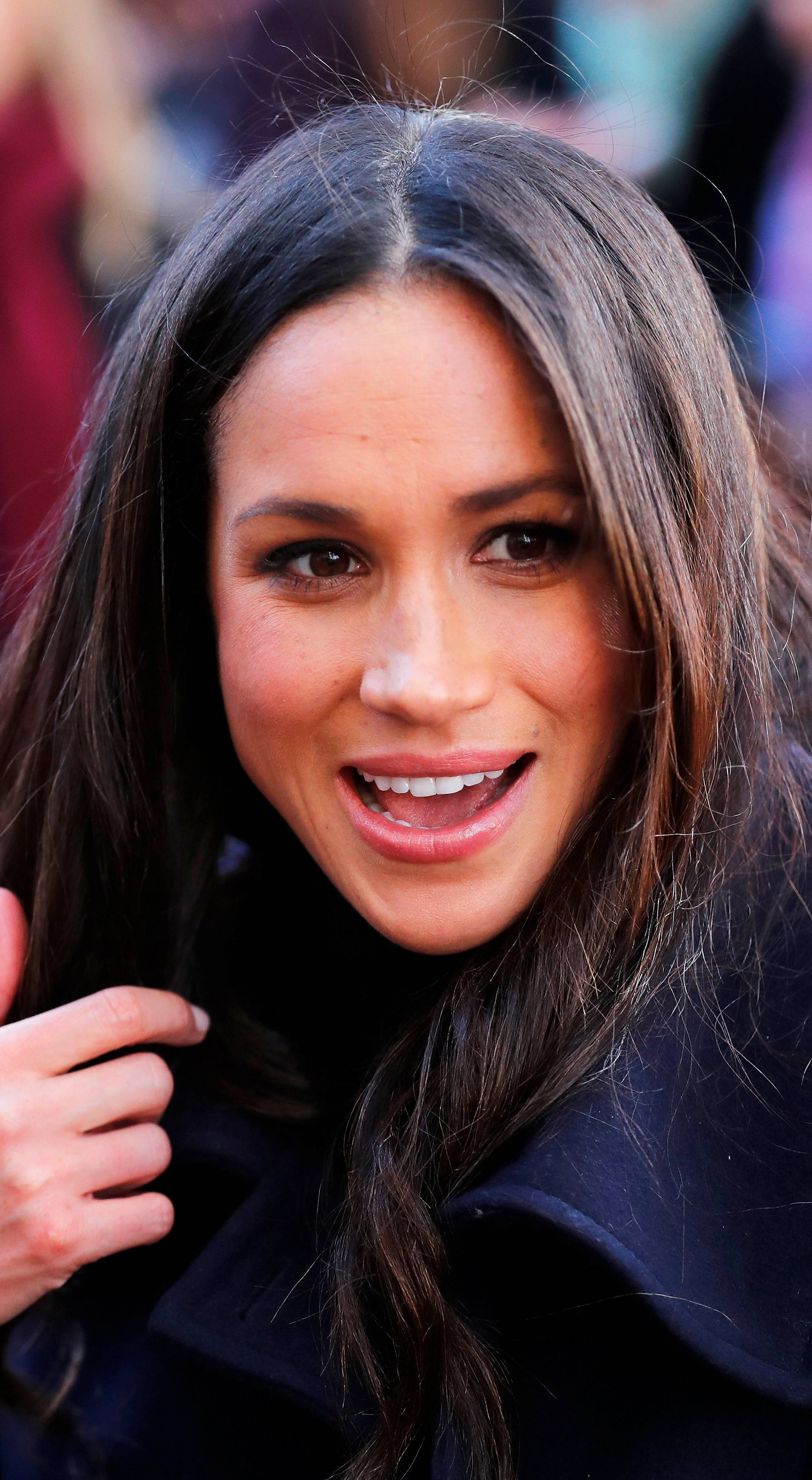 Meghan Markle greets well wishers as she arrives at an event with her fiancee Britain's Prince Harry in Nottingham