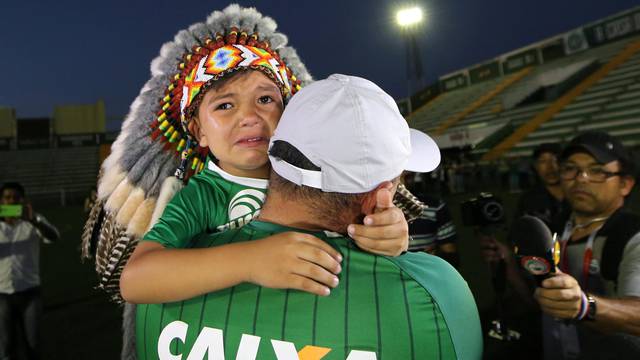 A fan of Chapecoense soccer team and his son react at the Arena Conda stadium in Chapeco