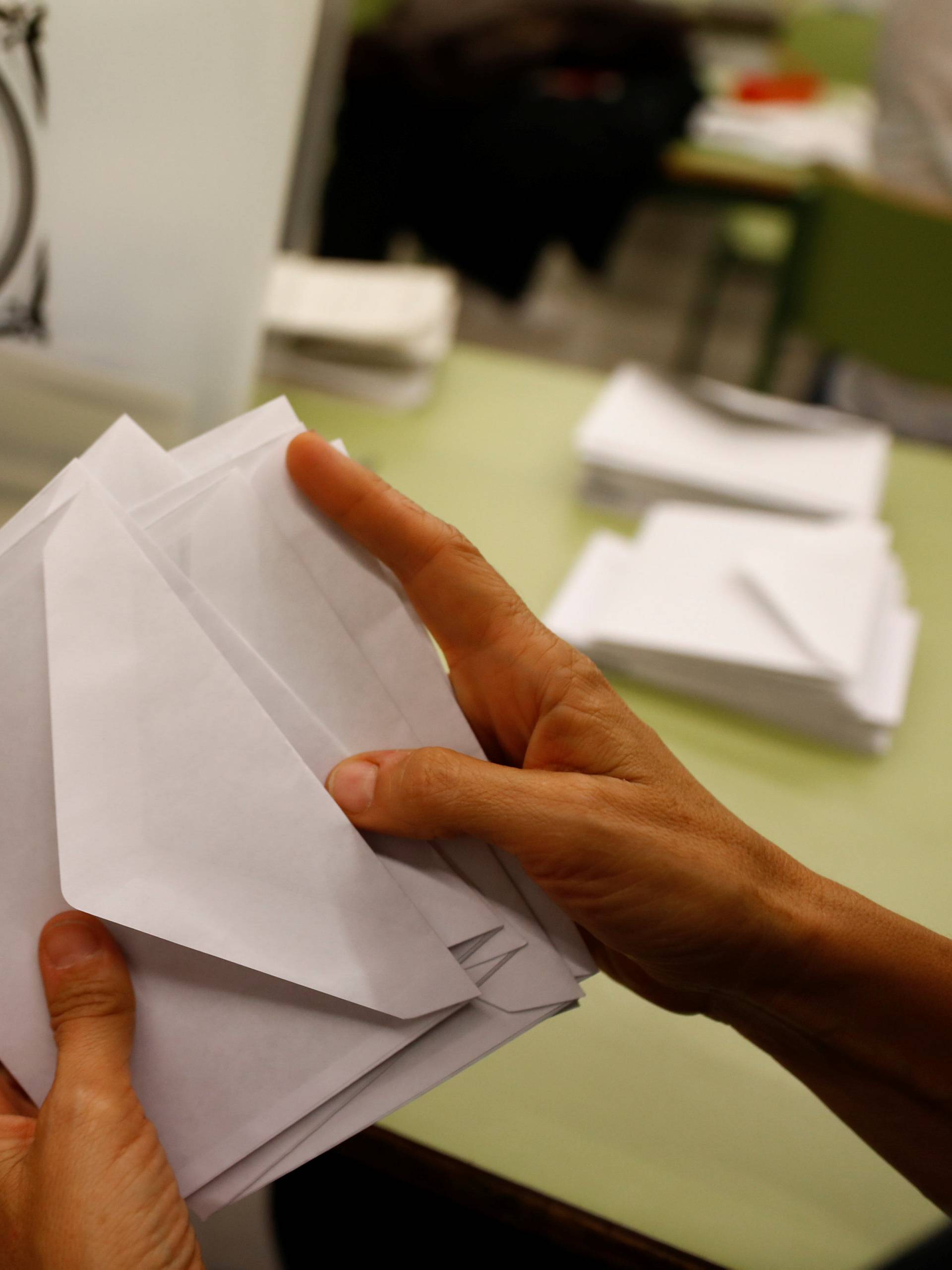 Poll workers count ballots after polls closed at a polling station for the banned independence referendum in Barcelona