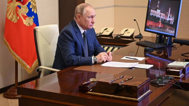 Russian President Putin takes part in a video link outside Moscow