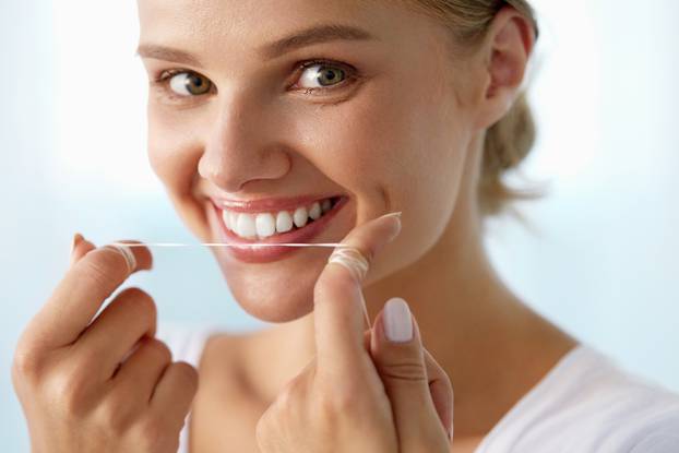 Dental Care. Woman With Beautiful Smile Using Floss For Teeth