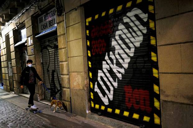 FILE PHOTO: FILE PHOTO: A woman is pictured with her dog in Barcelona, Spain, during an October lockdown to curb the spread of COVID-19