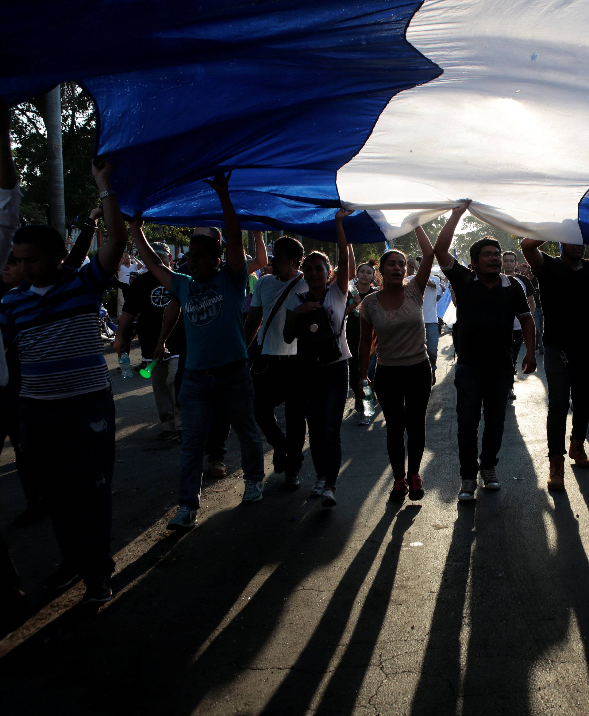 Demonstrators hold up a large Nicaraguan flag during a protest against police violence and the government of Nicaraguan President Daniel Ortega in Managua