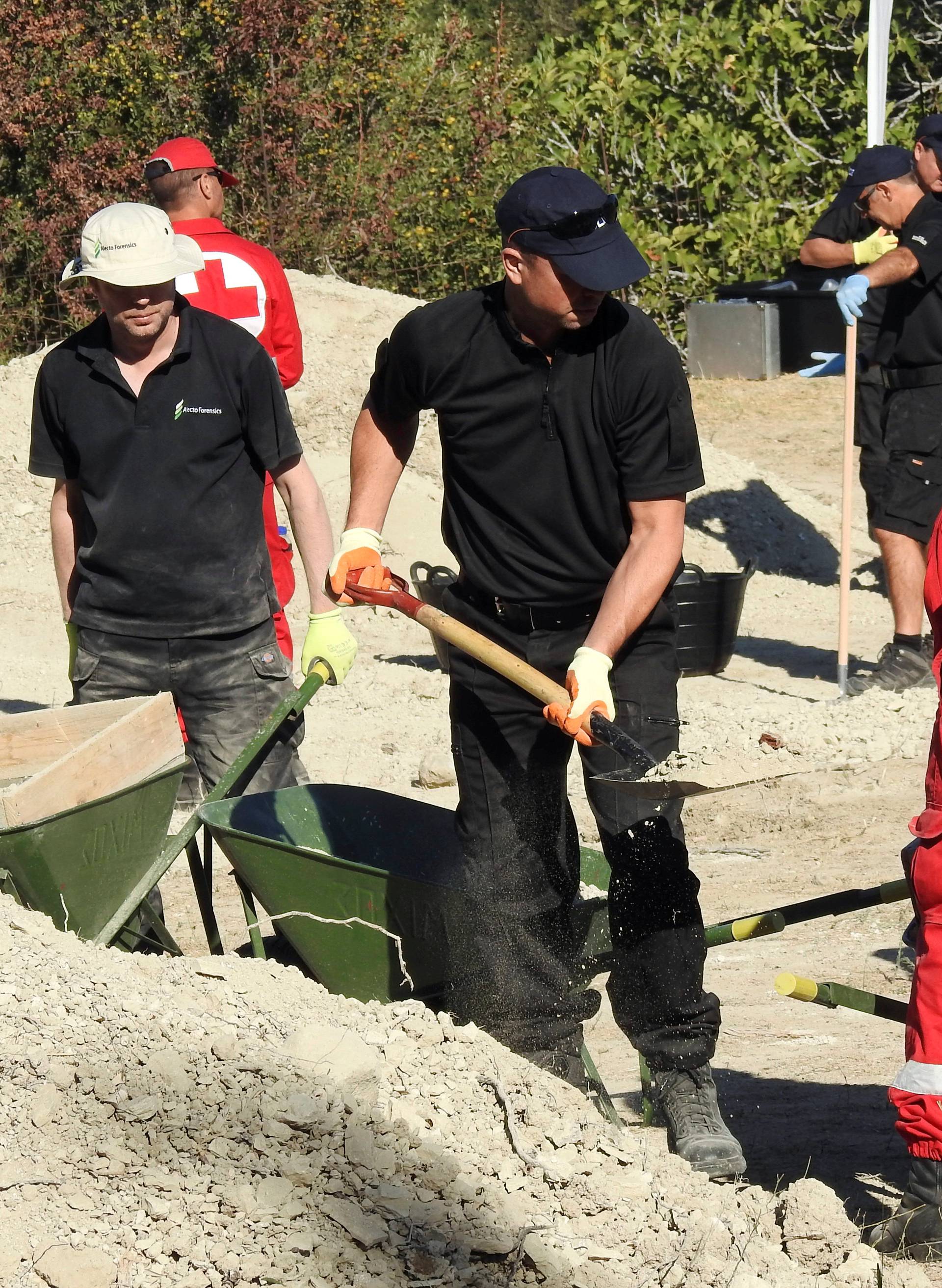 South Yorkshire police officers and members of the Greek rescue service investigate the ground while excavating a site during an investigation for Ben Needham on the island of Kos