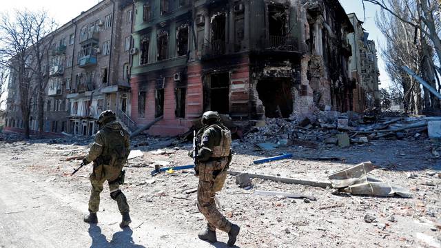 FILE PHOTO: Service members of pro-Russian troops inspect streets of Mariupol