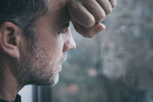 portrait one sad man standing near a window