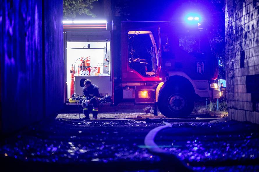 An emergency worker rests after extinguishing a fire in an apartment building following a Russian drone attack in Kyiv